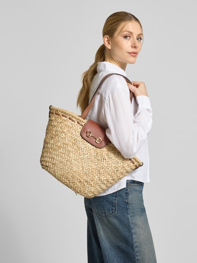 Frauenmodel trägt Shopper aus reiner Baumwolle in Bast-Optik Modell 'CIES' von Mango, Zier-Applikation in metallic, Ganzkörperansicht Rückansicht.
