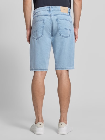 Männermodel trägt Regular Fit Jeansshorts aus Baumwoll-Mix von s.Oliver RED LABEL in heller Denim-Optik mit Label-Patch, Nieten und 5-Pocket-Design, Ganzkörperansicht Rückansicht.