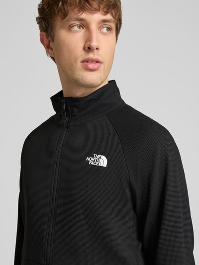 Männermodel trägt Jacke mit Raglanärmel und Logo-Print Modell 'PACKABLE KECHA' von The North Face, Schwarz, Material-Mix mit Stretch-Anteil, Nahaufnahme Oberkörper