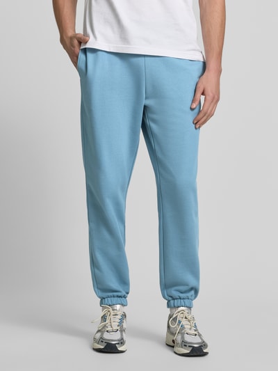 Männermodel trägt Regular Fit Sweathose aus Baumwoll-Mix von Lacoste in Hellblau mit geradem Schnitt, Nahaufnahme Unterkörper, Herren Sweathose von Lacoste.