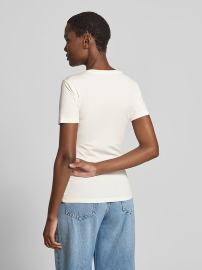Vrouwenmodel draagt T-shirt met siersteentjes model 'Shelly' van GUIDO MARIA KRETSCHMER WOMAN van materiaalmix met stretch, slim fit, ronde hals, ruglengte bij maat 36 59 cm, lichte crème kleur, gladde structuur, effen design, geheelbeeld achteraanzicht