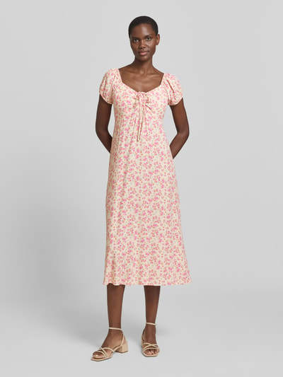 Modelka kobieca nosi Midikleid mit Puffärmeln od GAP w drobny kwiatowy wzór, przylegający krój, dekolt serce, marszczenia, bufiaste rękawy, wiązanie, długość tyłu w rozmiarze S: 102 cm, szerokość w rozmiarze S: 40 cm, długość rękawa w rozmiarze S: 12 cm, pełny widok sylwetki z przodu