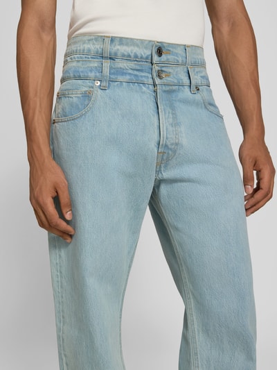 Männermodel trägt Regular Fit Jeans mit Label-Detail von VETEMENTS aus reiner Baumwolle, 5-Pocket-Design, hellblau, Nahaufnahme Oberkörper.