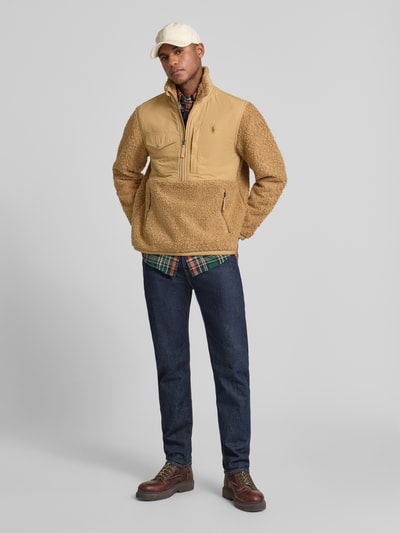 Männermodel trägt Regular Fit Troyer in Teddyfell-Optik von Polo Ralph Lauren in Unifarben mit Struktur, Label-Stitching, Logo-Detail, Rückenpasse, kurzem Reißverschluss und mehreren Reißverschlusstaschen, elastischem Langarm- und Rumpfabschluss, Materialverarbeitung Teddyfell, Ganzkörperansicht von vorne.