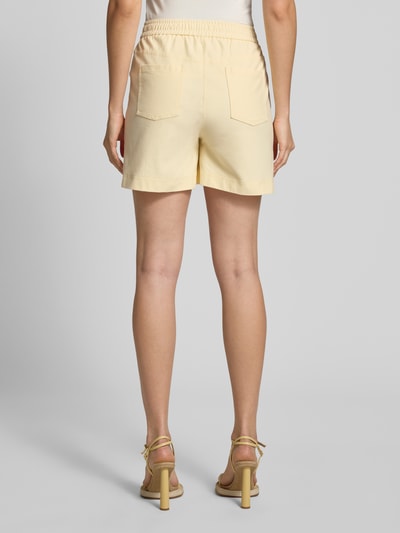 Frauenmodel trägt Shorts mit elastischem Bund Modell 'KATE' von ICHI aus Baumwoll-Mix mit Stretch-Anteil, Regular-Fit, Eingrifftaschen, cremefarbener Look, Ganzkörperansicht Rückansicht.