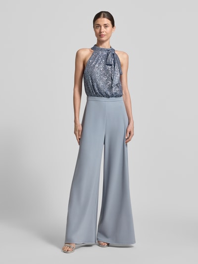 Vrouwenmodel draagt Regular Fit Jumpsuit met paillettenbesatz van Swing in lichtblauw, opstaande kraag, getailleerd, mouwloos design, sierstrik, rugdecolleté, elastische materiaalmix, regular fit, totale lengte 155 cm, binnenbeenlengte 78 cm, borstwijdte 34 cm, ruglengte 43 cm, full body aanzicht van voren.