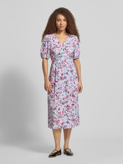 Vrouwenmodel draagt Tailliertes Freizeitkleid aus Viskose-Baumwoll-Mix van Marc O'Polo Denim met all-over motief, getailleerde pasvorm, midilengte, diepe V-hals, riemlussen, korte knoopsluiting, bindceintuur, pofmouwen met elastische mouwboorden, zij-steekzakken, materiaal: mix van viscose en katoen, kleurmix van lila, rood en blauw, zachte textuur. Ganzkörperansicht van voren.