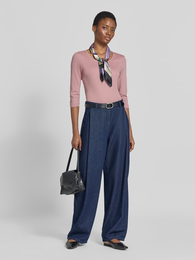 Frauenmodel trägt Shirt aus reiner Baumwolle von Christian Berg Woman in Rosa, kombiniert mit blauer Hose, Ganzkörperansicht von vorne. Rückenlänge bei Größe 36: 59 cm, gerader Schnitt, Rundhalsausschnitt, Halbärmeliges-Design.
