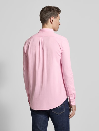 Männermodel trägt Regular Fit Freizeithemd aus reiner Baumwolle von Polo Ralph Lauren in effen roze met button-down kraag, lange mouw, sportmanchet en logo-stiksel, piquee katoen, geheel achteraanzicht.
