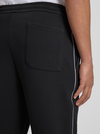 Männermodel trägt Regular Fit Sweatpants aus Baumwoll-Mix Modell 'JOIN HADIKO' von BOSS Green mit Piqué Material, Detailaufnahme.