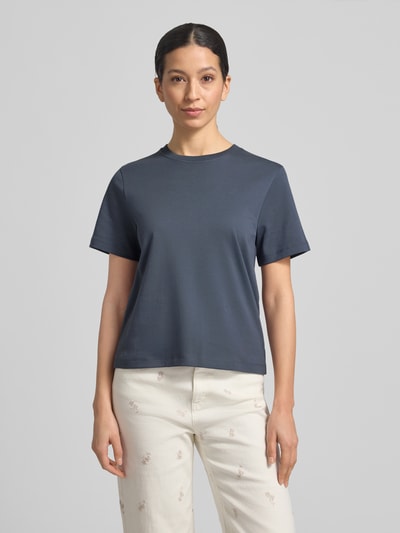 Modelka kobieca nosi Basic T-Shirt mit Rundhalsausschnitt von Christian Berg Woman z czystej bawełny, krój regular fit, jednolity kolor, długość tyłu w rozmiarze S: 53 cm, kolor niebieskoszary, gładka tekstura, widok całej sylwetki z przodu.