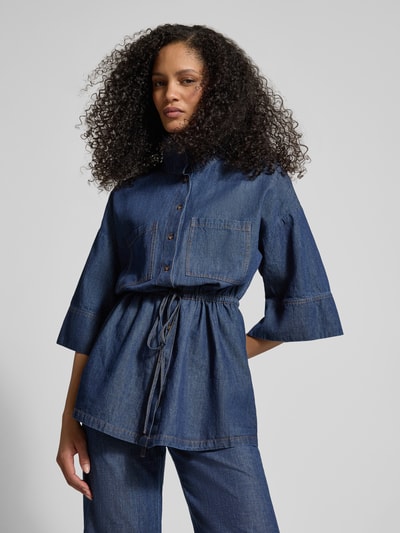 Kobiece modelka nosi Jeansbluse mit Stehkragen und Schnürung von Jake*s Collection, mieszanka bawełny i lnu, taliowany krój, stójka, wiązanie, rękaw o dł. 1/2, długość tyłu w rozmiarze 38: 76 cm, długość rękawów w rozmiarze 38: 30 cm, ciemnoniebieski denim, gładka faktura, widoczne przeszycia, widok całej sylwetki z przodu.