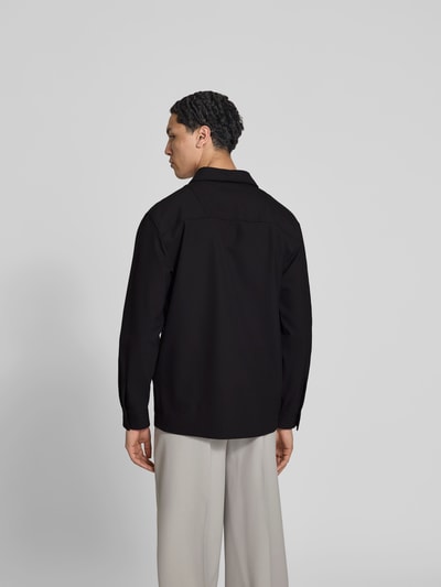 Männermodel trägt Freizeithemd mit Brusttasche von Closed in Schwarz, lockerer Schnitt, glatter Stoff, Rückenansicht, Ganzkörperansicht Rückansicht.