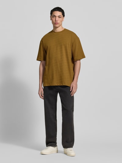 Männermodel trägt T-Shirt mit Rundhalsausschnitt Modell 'KAISER' von Blend in Braun, Relaxed Fit, reine Baumwolle, Ganzkörperansicht von vorne.