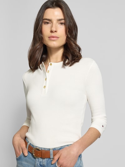 Frauenmodel trägt Slim Fit T-Shirt aus reiner Baumwolle von Tommy Hilfiger, Optik: unifarben, 3/4-Arm, Feinripp, Logo-Detail, Nahaufnahme Oberkörper.