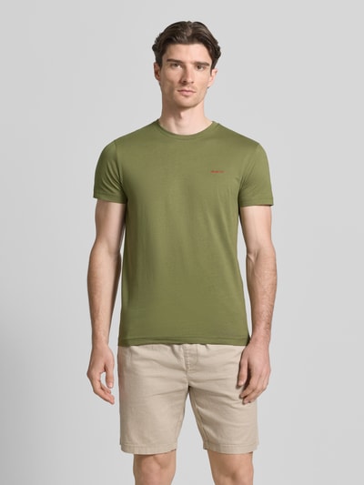 Männermodel trägt T-Shirt mit Label-Detail von Gant in Khaki, reine Baumwolle, gerader Schnitt, Rundhalsausschnitt, Ganzkörperansicht von vorne.