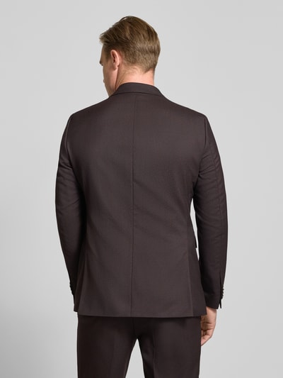 Männermodel trägt donkerbruin Slim Fit Sakko aus zuivere scheerwol Model 'Paul' van CG – CLUB of GENTS, gladde textuur, Ganzkörperansicht Rückansicht. Ruglengte bij maat 50: 74 cm, schouderbreedte: 45 cm, mouwlengte: 65 cm, reverskraag, 2-knoopsluiting, borstzak en klepzakken.