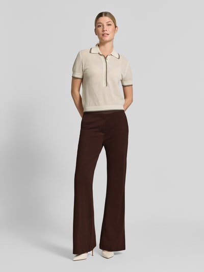 Frauenmodel trägt Flared Cut Hose aus Viskose-Mix mit Gesäßtaschen von Christian Berg Woman, braun, schlichte Textur, Ganzkörperansicht von vorne.