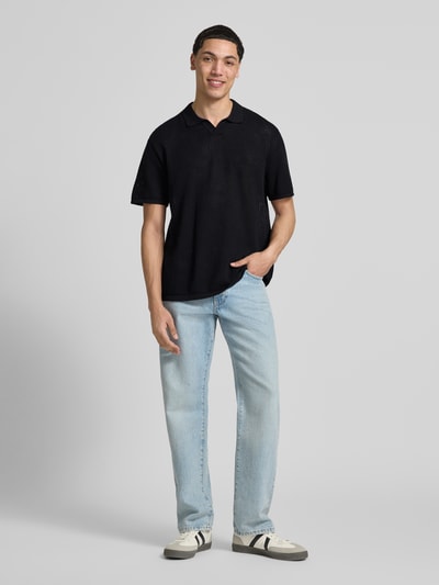 Männermodel trägt Strickshirt mit Baumwoll-Anteil Modell 'JERRY' von Jack & Jones, Bio-Baumwoll-Mix, Gerader-Schnitt, Umlegekragen, Semitransparente-Optik, Rückansicht Ganzkörperansicht von vorne.