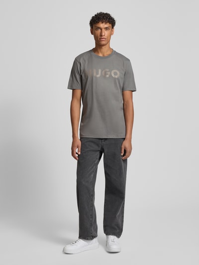 Männermodel trägt Relaxed Fit T-Shirt aus reiner Baumwolle Modell 'DULIVIO' von HUGO, Optik: Unifarben, Label-Schriftzug, Ganzkörperansicht von vorne
