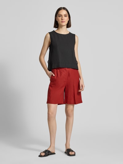 Kobieta nosi Wide Fit Shorts aus reinem Leinen mit Tunnelzug von Marc O'Polo, efekt: jednolity kolor, materiał: len, wpuszczane kieszenie, lamowana kieszeń, średni stan, tunel, zapięcie na haftkę i ukryty zamek błyskawiczny, krój wide fit. Ganzkörperansicht von vorne.