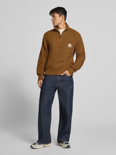 Männermodel trägt Troyer mit Brustleistentasche Modell 'DETROIT' von Carhartt Work In Progress, Material-Mix, braun, Ganzkörperansicht von vorne.
