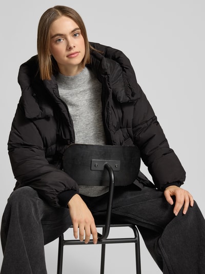 Frauenmodel trägt Regular Fit Steppjacke mit Kapuze Modell 'CORNELIA' von Only, Optik: Unifarben, Label-Stitching-Applikation, Stehkragen, Reißverschluss, Langarm mit Storm Cuffs, seitliche Eingrifftaschen, Ganzkörperansicht von vorne.