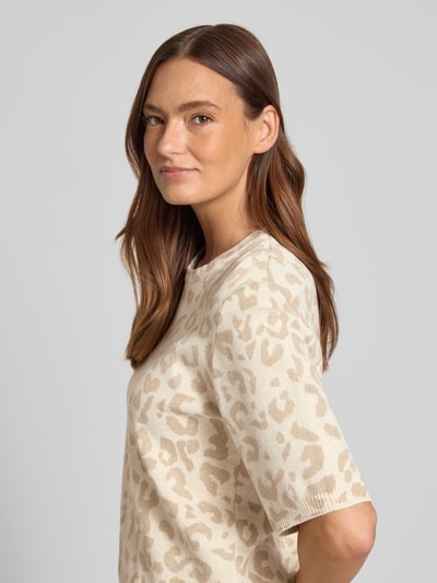 Frauenmodel trägt Relaxed Fit Shirt aus Viskose-Anteil Modell 'Mayas' von Vila, Material-Mix, Strick-Optik, Allover-Animal-Print, Halbarm, Rundhalsausschnitt, in Beige und Creme mit weicher Textur, Nahaufnahme Oberkörper.