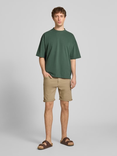 Männermodel trägt Jeansshorts mit Umschlag und Eingrifftaschen Modell 'RICK ALLEN' von Jack & Jones, beige, Regular Fit, Baumwoll-Elasthan-Mix, Ganzkörperansicht von vorne.