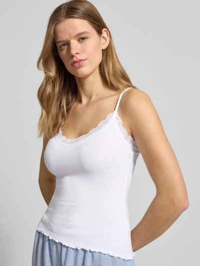 Frauenmodel trägt Slim Fit Top aus Viskose-Mix mit Spitzenbesatz von Review in Weiß, feine Rippenstruktur, Spaghettiträger, Nahaufnahme Oberkörper.