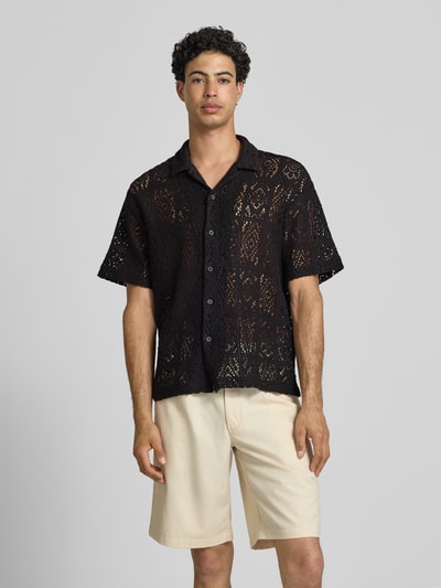 Männermodel trägt Relaxed Fit Freizeithemd aus Baumwoll-Mix Modell 'AVON' von Only & Sons, unifarben schwarz, Strickstruktur, Resortkragen, durchgehende Knopfleiste, kurzarm, Ganzkörperansicht von vorne.