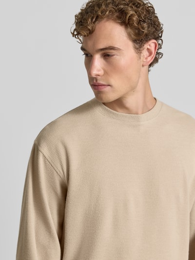 Männermodel trägt pullover met ronde hals Model 'KARIO' van DRYKORN in beige Materiaalmix katoenmix textuur, los model, Nahaufnahme Oberkörper, Ruglengte maat M 70 cm, Mouwlengte 64 cm.