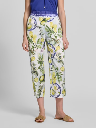 Kobiece model nosi Straight Fit Stoffhose aus reiner Viskose mit Allover-Motiv-Print von Marc Cain, białe spodnie materiałowe z nadrukiem z motywem na całej powierzchni, skrócony krój, częściowo elastyczny pas, szerokość w rozmiarze 36: 40 cm, długość wewnętrzna nogawki w rozmiarze 36: 64 cm, widok z przodu na całe ciało.