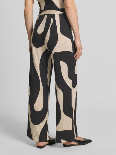Frauenmodel trägt Stoffhose aus Viskose-Mix im Allover-Look Modell 'NIKITA' von Mango, Relaxed-Fit, strukturiertes Material, Ganzkörperansicht Rückansicht. Damen Stoffhose, Bundweite bei Größe 36: 41 cm, Innenbeinlänge bei Größe 36: 77 cm.