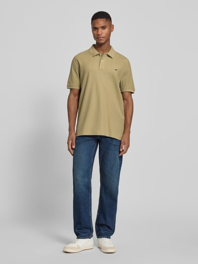 Männermodel trägt Regular Fit Poloshirt mit Logo-Stitching von Fynch-Hatton in Beige, reine Baumwolle, Polokragen, Ganzkörperansicht von vorne.