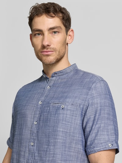 Männermodel trägt Regular Fit Freizeithemd mit Brusttasche von Christian Berg Men in Blau mit Stehkragen und Kurzarm, Nahaufnahme Oberkörper.