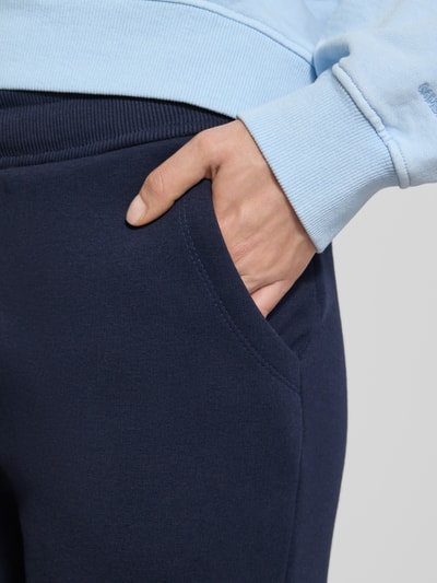 Frauenmodel trägt Sweatpants mit elastischem Bund von Christian Berg Woman aus Baumwoll-Mix, Tunnelzug, französische Eingrifftaschen, Detailaufnahme.