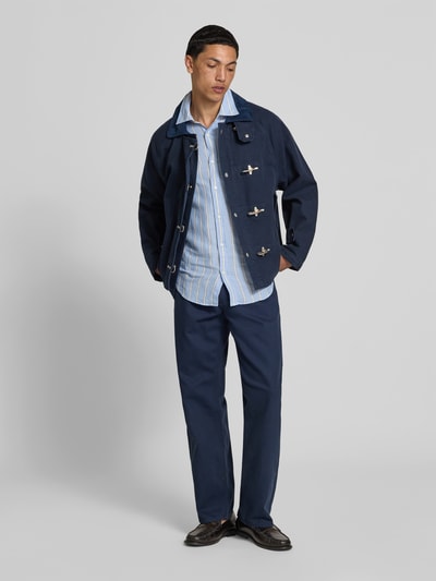 Männermodel trägt Regular Fit Jacke mit Umlegekragen von Forét aus Reine Baumwolle, Dunkelblau, Eingrifftaschen, Verschlussschnallen, Ganzkörperansicht von vorne.