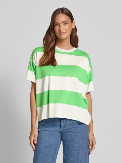 Frauenmodel trägt Relaxed Fit Shirt aus Viskose-Mix Modell 'LULS' von ICHI mit grünen und weißen Blockstreifen, Rundhalsausschnitt, oversized geschnitten, Rückenlänge 62 cm, Ärmellänge 18 cm, Ganzkörperansicht von vorne.