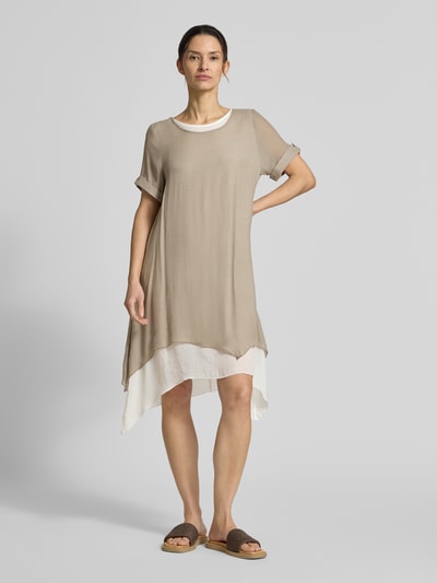 Kobiece modelka nosi Knielanges Kleid aus Viskose-Mix od Apricot w beżowym kolorze, prosty krój, długość do kolan, okrągły dekolt, rękawy z podwinięciem, długość tyłu w rozmiarze S: 94 cm, szerokość w rozmiarze S: 49 cm, długość rękawa w rozmiarze S: 22 cm, całopostaciowy widok z przodu.