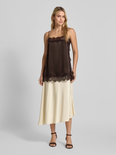 Kobiece model prezentuje jednokolorowy top z koronki i obszyciem koronką, dekolt w serek, cienkie ramiączka, bez rękawów, z bocznymi rozcięciami, Relaxed Fit Top mit Spitzenbesatz Modell 'CHARM LACE SINGLET' od VERO MODA, widok całej sylwetki z przodu.