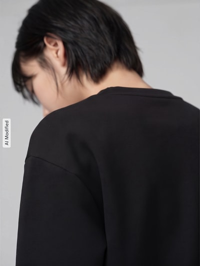 Frauenmodel trägt Regular Fit Sweatshirt mit Baumwoll-Anteil von Lacoste, glatter schwarzer Stoff, Detailaufnahme des Rückens, Damen Sweatshirt von Lacoste Sport, KI-modifiziertes Bild.