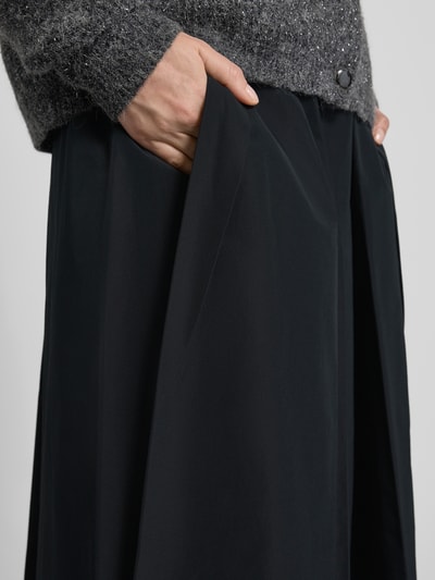 Kobiece model prezentuje czarny Midi-Rock mit Baumwoll-Anteil Modell 'CURVATO' od Weekend Max Mara, gładka tkanina, zbliżenie na biodra, detal.