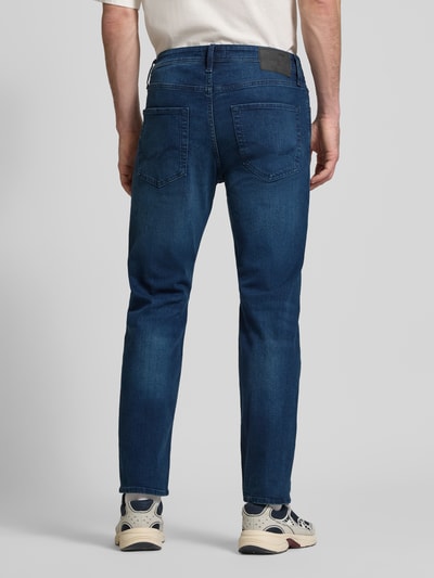 Männermodel draagt Straight Fit Jeans uit mix van katoen en elastaan Model 'CLARK ORIGINAL' van JACK & JONES, 5-pocketmodel, donkerblauw, knoop- en ritssluiting, bandwijdte maat 32/32 43 cm, binnenbeenlengte 75 cm, ganzekörperaanzicht achteraan.
