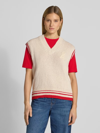 Vrouwenmodel draagt spencer Loose Fit Pullunder aus Baumwoll-Mix Modell 'ICONIC A COLLEGE' van Armedangels in effen gebreide look met gestikt logo, contraststrepen, v-hals en geribde rompzoom, katoenmix; geheel vooraanzicht, bovenlichaam.
