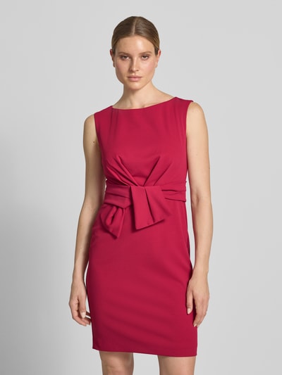 Frauenmodel trägt Knielanges Cocktailkleid mit Knotendetail von Vera Mont, Material-Mix mit Stretch-Anteil, Gerader-Schnitt, Rundhalsausschnitt, in kräftigem Pink, glatte Textur, Knielänge, Größe 36, Brustweite 47 cm, Rückenlänge 93 cm, Ganzkörperansicht von vorne.