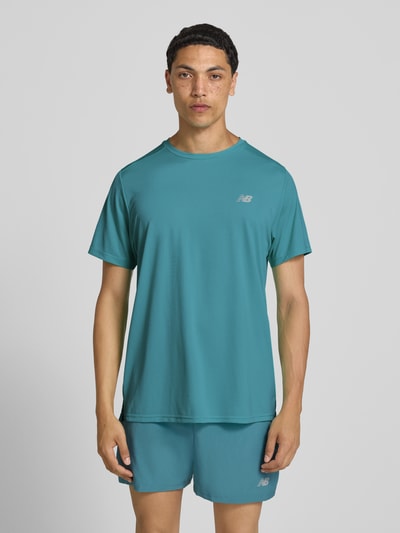 Męski model nosi Funktionsshirt mit Rundhalsausschnitt und Logo od New Balance, niebieski, krój regular fit, okrągły dekolt, logo, długość tyłu w rozmiarze m: 69 cm, całkowity widok z przodu.
