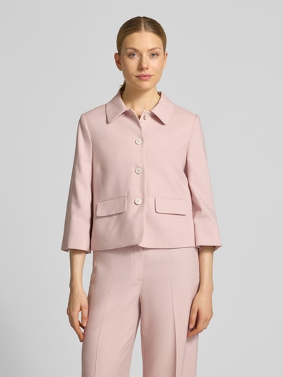 Modelka nosi Regular Fit Blazer aus Viskose-Mix mit Pattentaschen od More & More, jasnoróżowy, krój regular fit, kołnierz wykładany, zapięcie na guziki, patkowe kieszenie, długość tyłu w rozmiarze 36: 51 cm, szerokość w rozmiarze 36: 47 cm, długość rękawa w rozmiarze 36: 46 cm, gładka faktura, widok całej sylwetki z przodu.