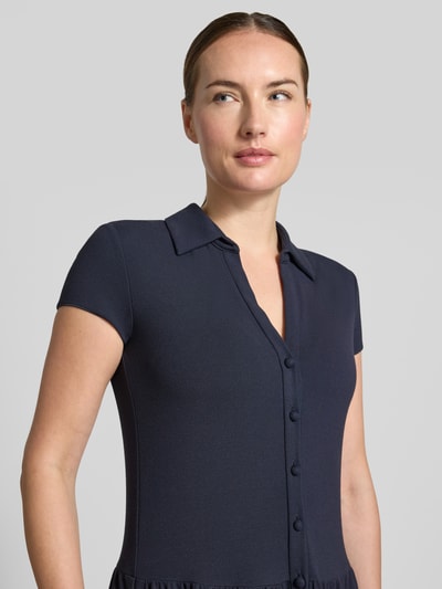 Frauenmodel trägt Midikleid aus Viskose-Mix von Emporio Armani in Dunkelblau mit Umlegekragen und Knopfleiste, Nahaufnahme Oberkörper.