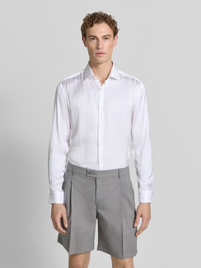 Männermodel trägt weißes Slim-Fit Businesshemd aus reiner Viskose Modell 'KENNO' von HUGO, graue Shorts, Ganzkörperansicht von vorne. Herren Businesshemd von HUGO.